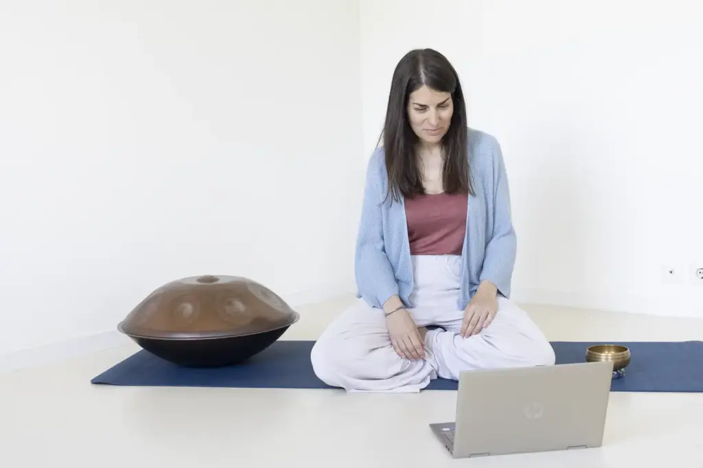 Esther Mambrilla en una sesión online de mindfulness con handpan y portátil