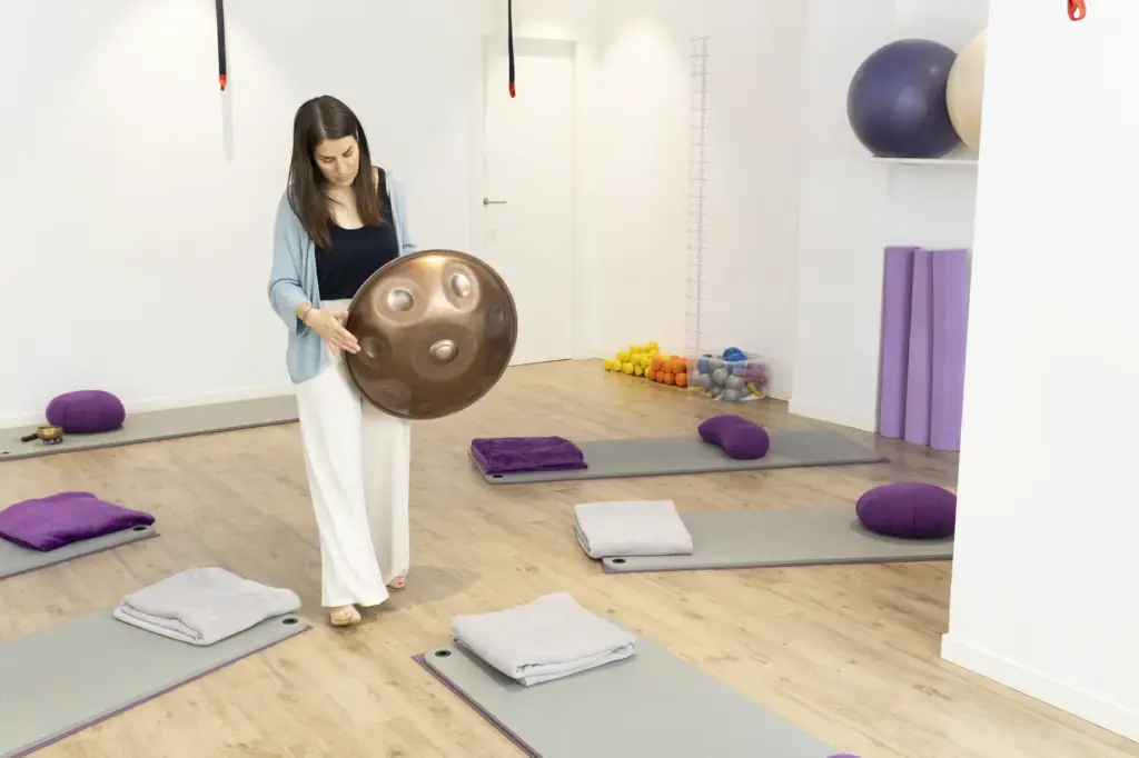 Esther Mambrilla tocando el handpan en una sesión presencial en el centro FISIONA